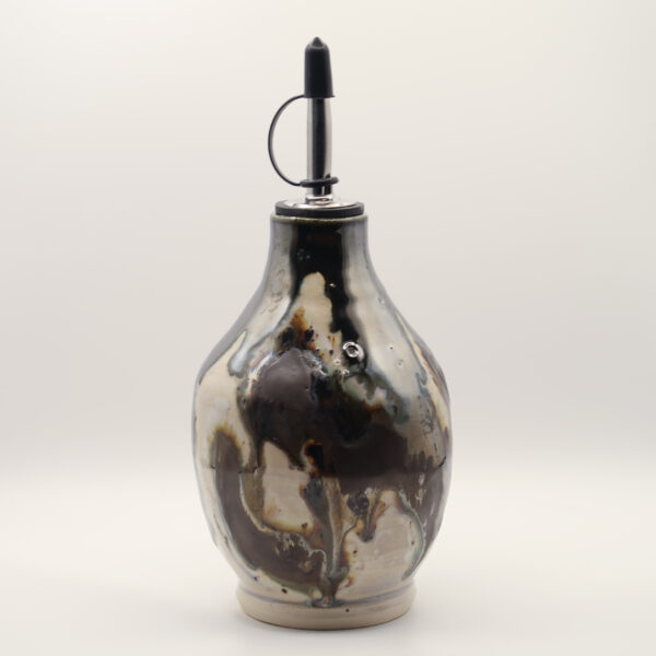 Ceramic oil bottle with swirling black, brown and cream glaze, unglazed base and metal pourer spout with black cap