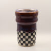 IMG_4212 Ceramic travel cup with clear plastic lid, glossy deep purple-brown glaze dripping over a black and white checkerboard base