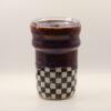 IMG_4213 Ceramic travel cup with glossy deep purple-brown glaze over a black and white checkerboard base, topped with a clear plastic