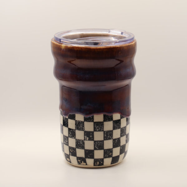 IMG_4213 Ceramic travel cup with glossy deep purple-brown glaze over a black and white checkerboard base, topped with a clear plastic