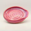 IMG_4225 Ceramic spoon rest in pink and lilac glaze with a carved spiral in the base and a pinched notch at one end