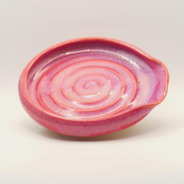 IMG_4225 Ceramic spoon rest in pink and lilac glaze with a carved spiral in the base and a pinched notch at one end